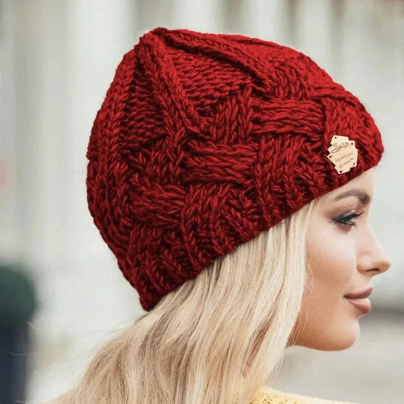 Knitted cable-pattern beanie with decorative patch