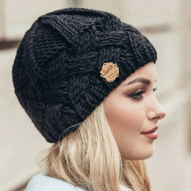 Knitted cable-pattern beanie with decorative patch