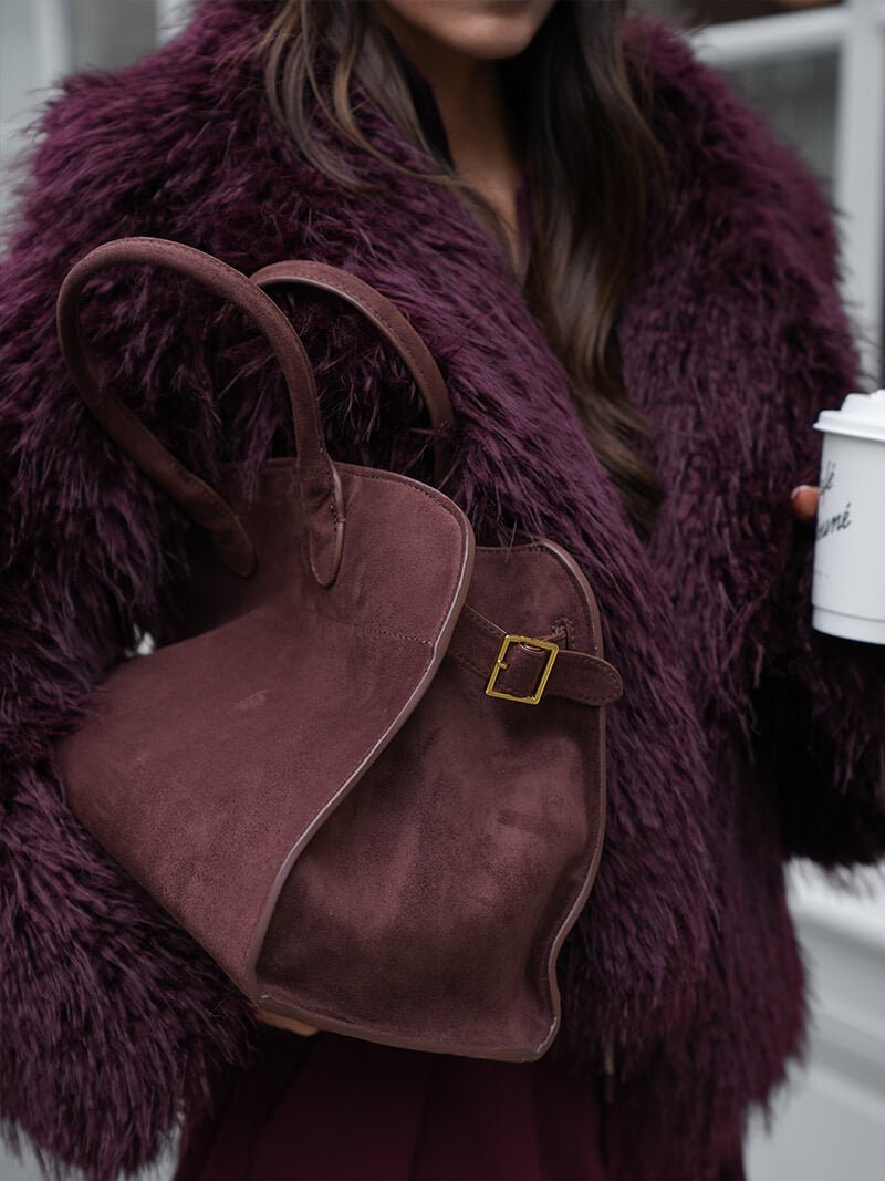 Handbag with textured material and zipper closure