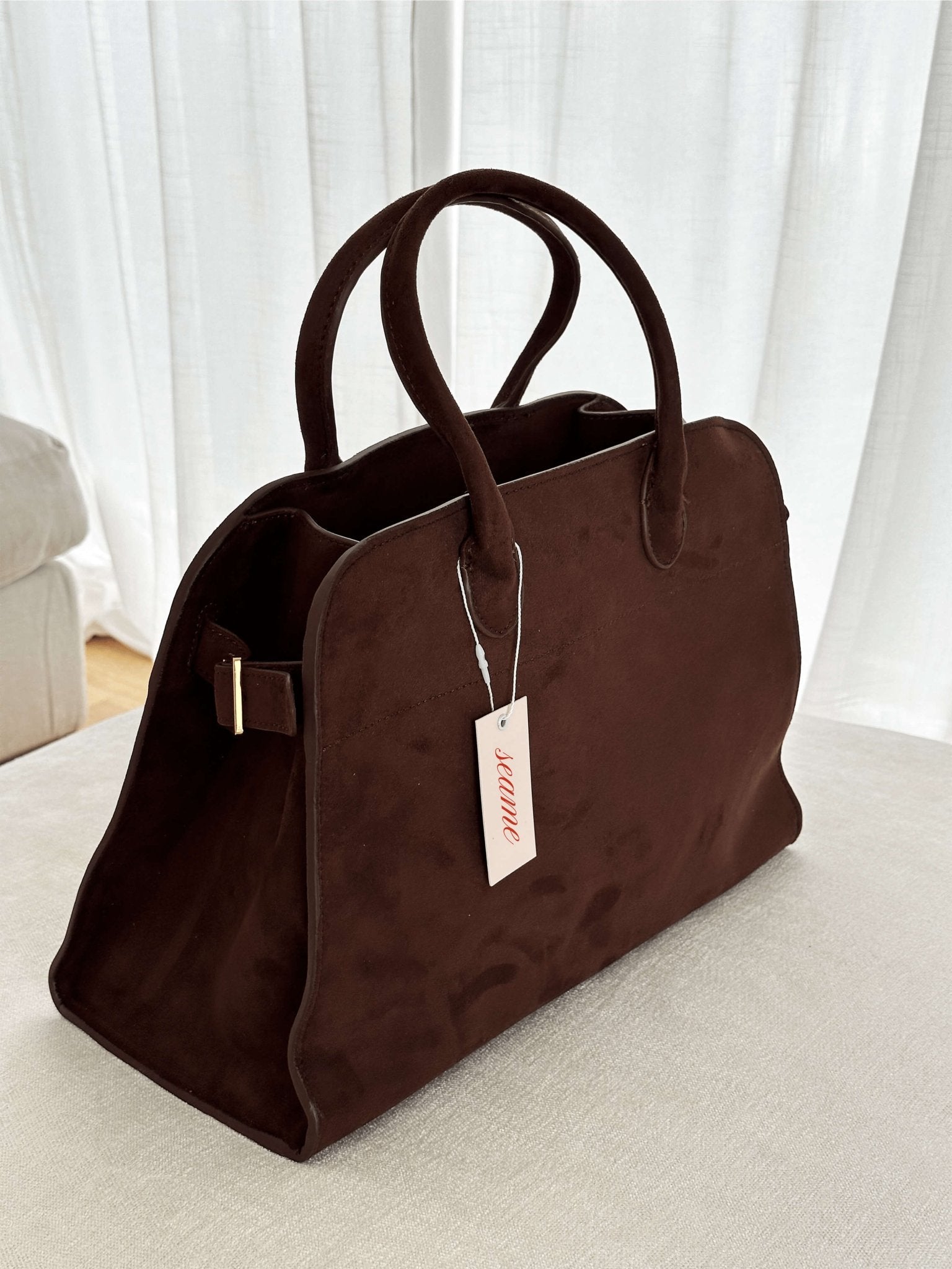Handbag with textured material and zipper closure