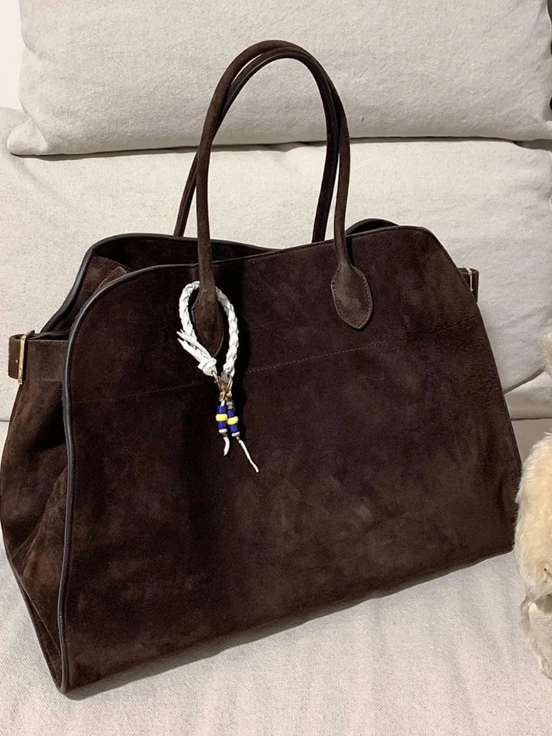 Handbag with textured material and zipper closure