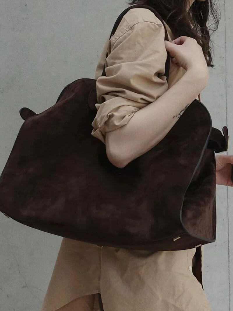 Handbag with textured material and zipper closure