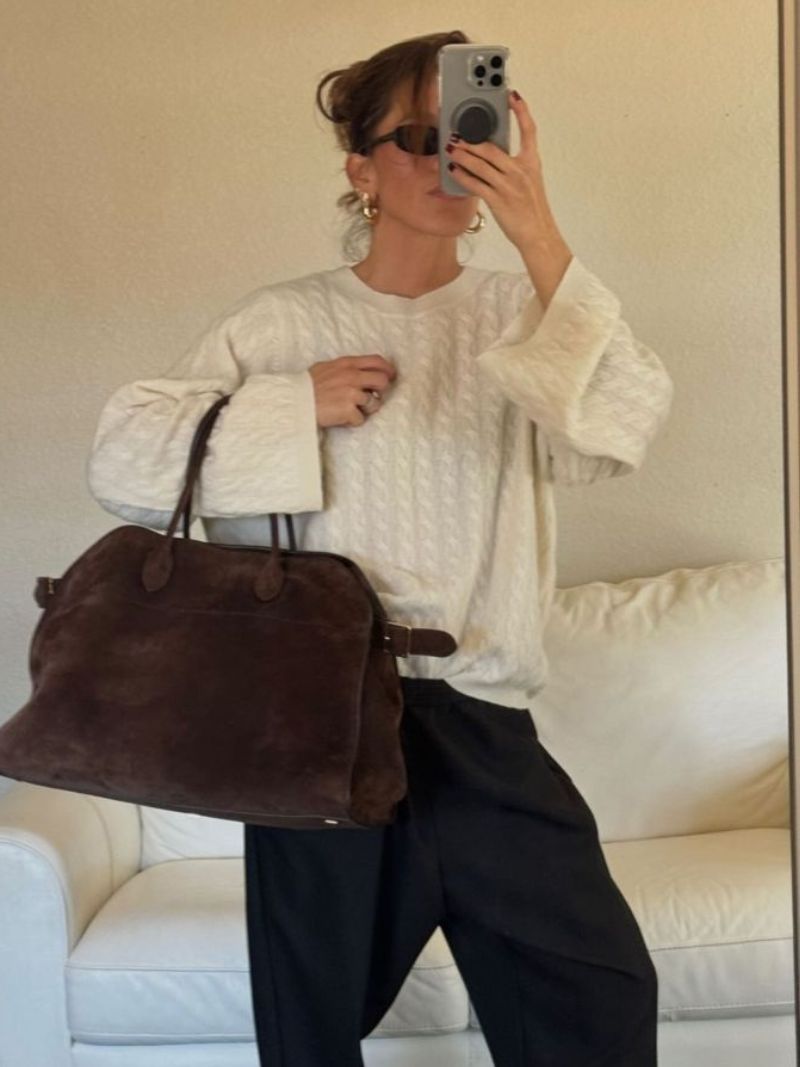 Handbag with textured material and zipper closure