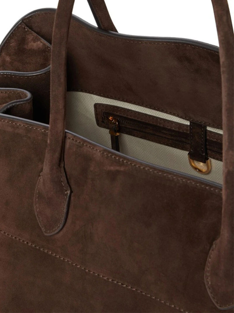 Handbag with textured material and zipper closure