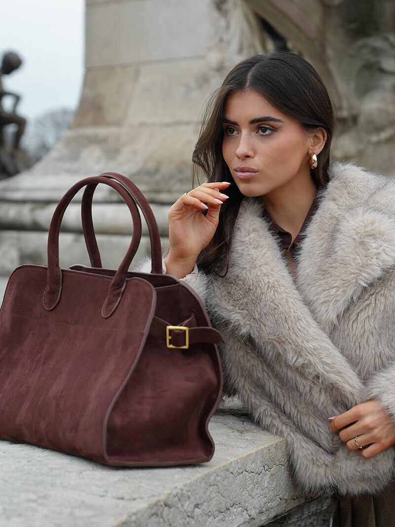Handbag with textured material and zipper closure