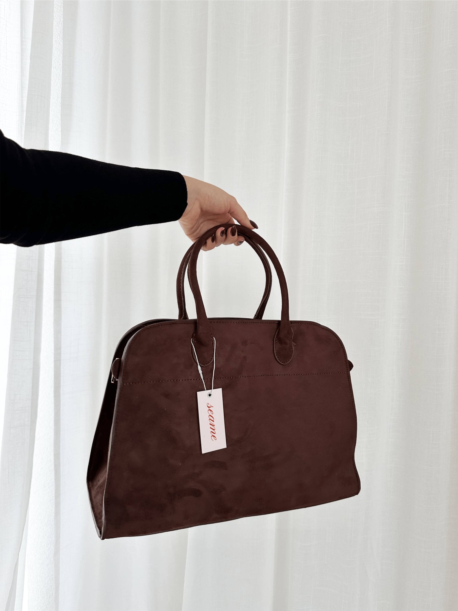 Handbag with textured material and zipper closure