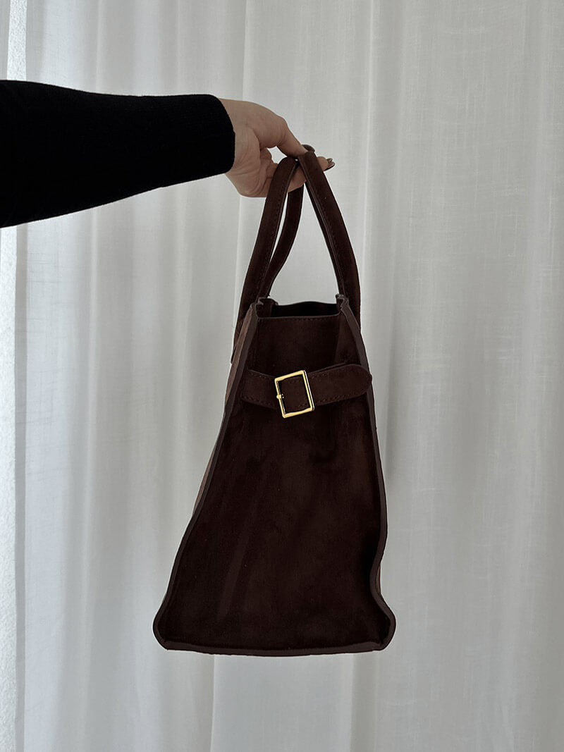 Handbag with textured material and zipper closure
