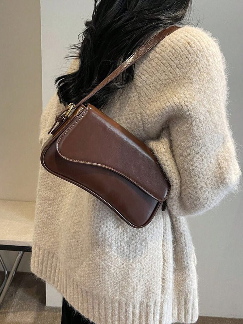Compact shoulder bag with curved front detail and snap closure