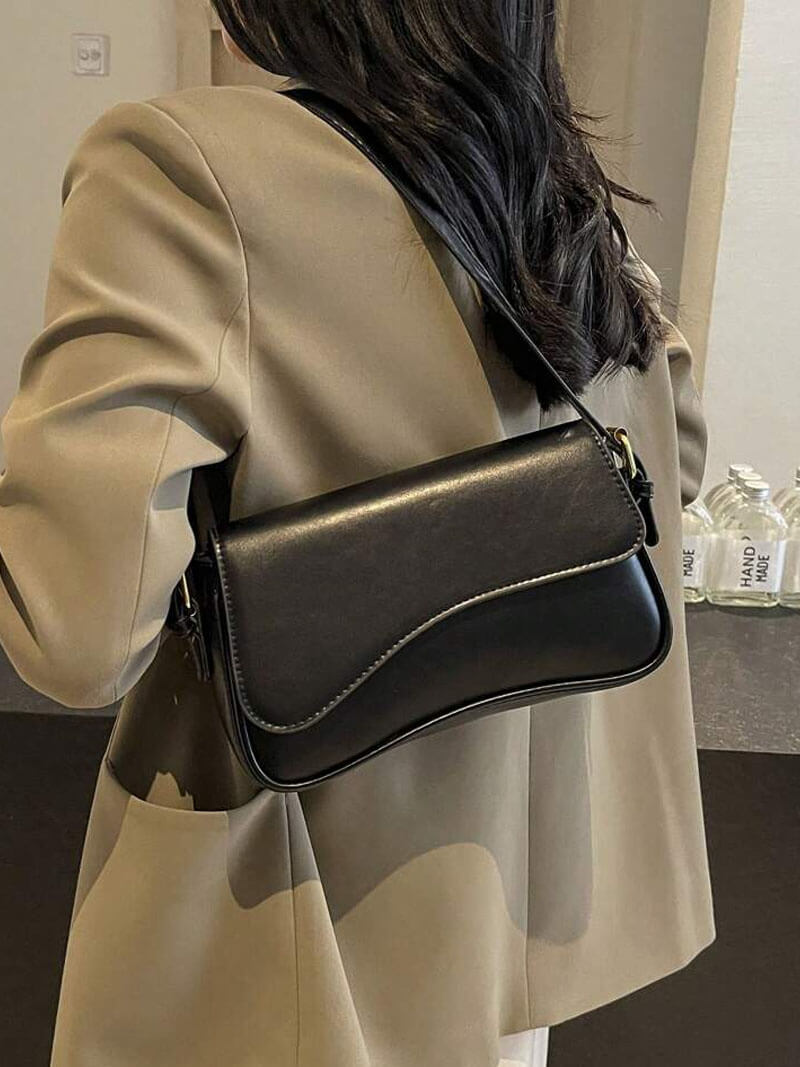 Compact shoulder bag with curved front detail and snap closure