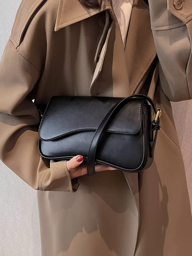 Compact shoulder bag with curved front detail and snap closure